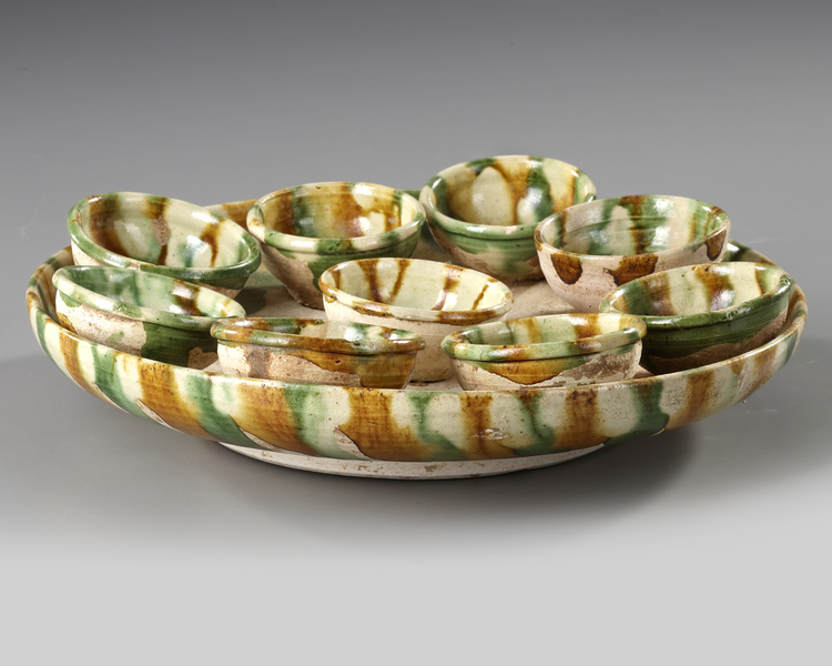 A CHINESE SANCAI GLAZED TRAY AND NINE CUPS, TANG DYNASTY (618906 AD)