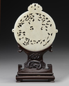 A CHINESE WHITE JADE ARCHAISTIC OPENWORK PLAQUE ON A WOODEN STAND, 19TH-20TH CENTURY