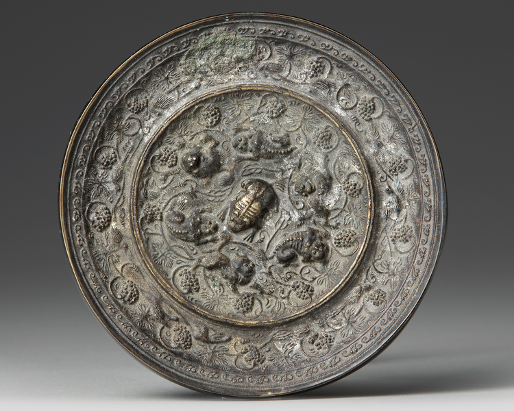 A CHINESE CIRCULAR "LIONS AND BIRDS" BRONZE MIRROR, TANG DYNASTY (618-907 AD)