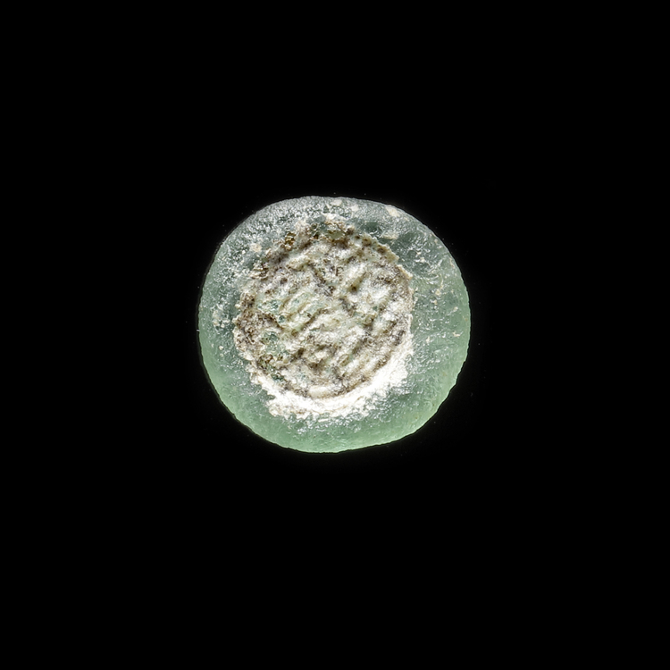 AN EARLY ISLAMIC GLASS WEIGHT OF HALF DIRHAM