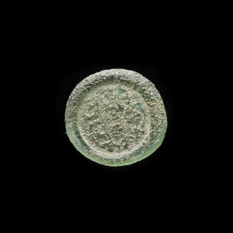 AN EARLY ISLAMIC  GLASS WEIGHT OF DIRHAM