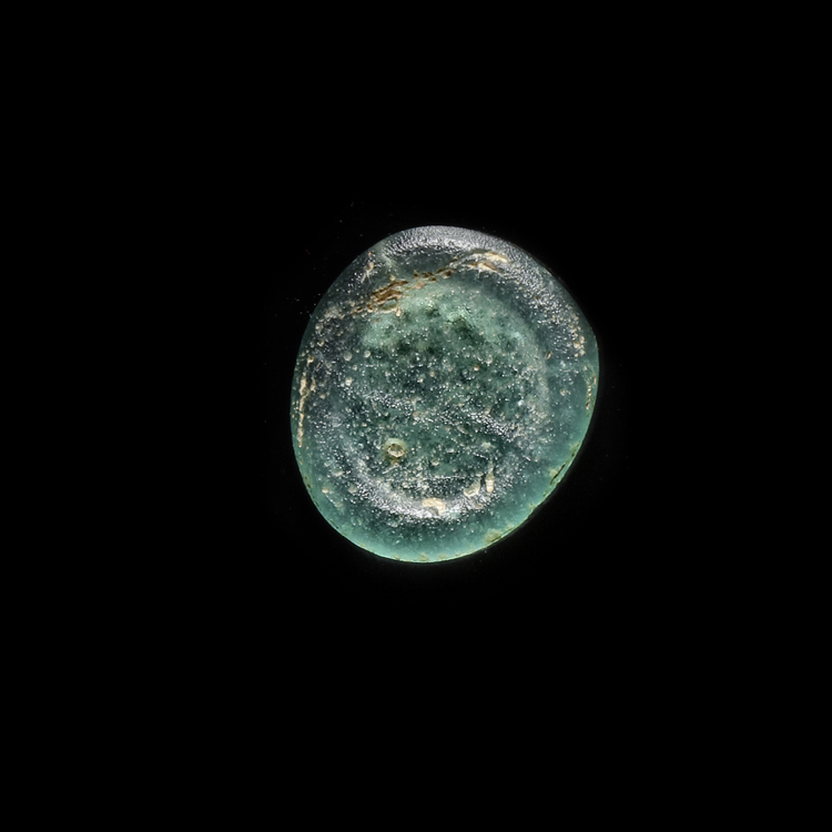 AN EARLY ISLAMIC GLASS WEIGHT OF HALF DIRHAM