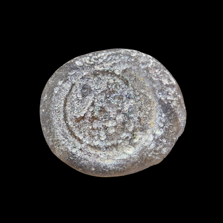 AN EARLY ISLAMIC GLASS WEIGHT OF HALF DINAR