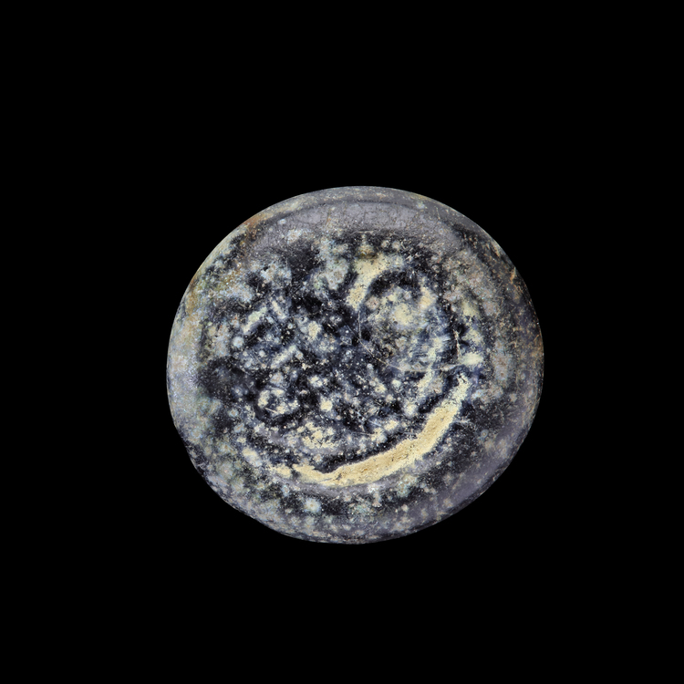 AN EARLY ISLAMIC GLASS WEIGHT OF HALF DINAR
