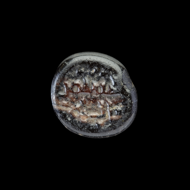 AN EARLY ISLAMIC GLASS WEIGHT OF QUARTER DIRHAM