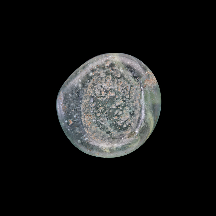 AN EARLY ISLAMIC GLASS WEIGHT OF HALF DINAR
