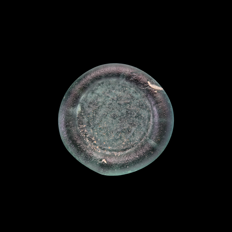 AN EARLY ISLAMIC GLASS WEIGHT OF HALF DIRHAM