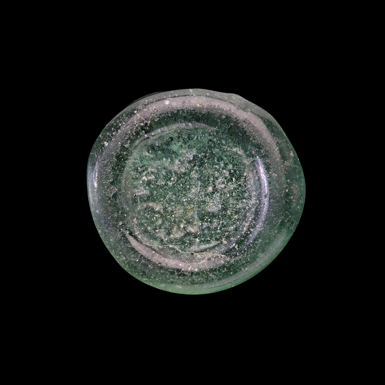 AN EARLY ISLAMIC GLASS WEIGHT OF HALF DIRHAM