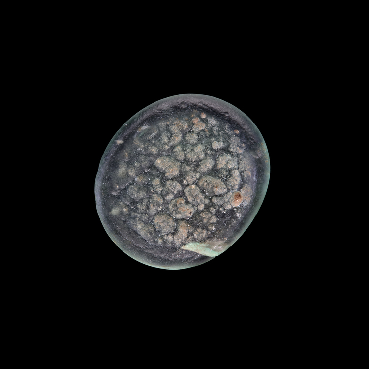 AN EARLY ISLAMIC GLASS WEIGHT OF HALF QUARTER DIRHAM