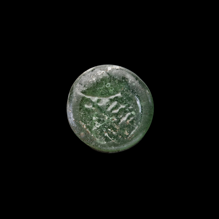 AN EARLY ISLAMIC GLASS WEIGHT OF HALF DIRHAM