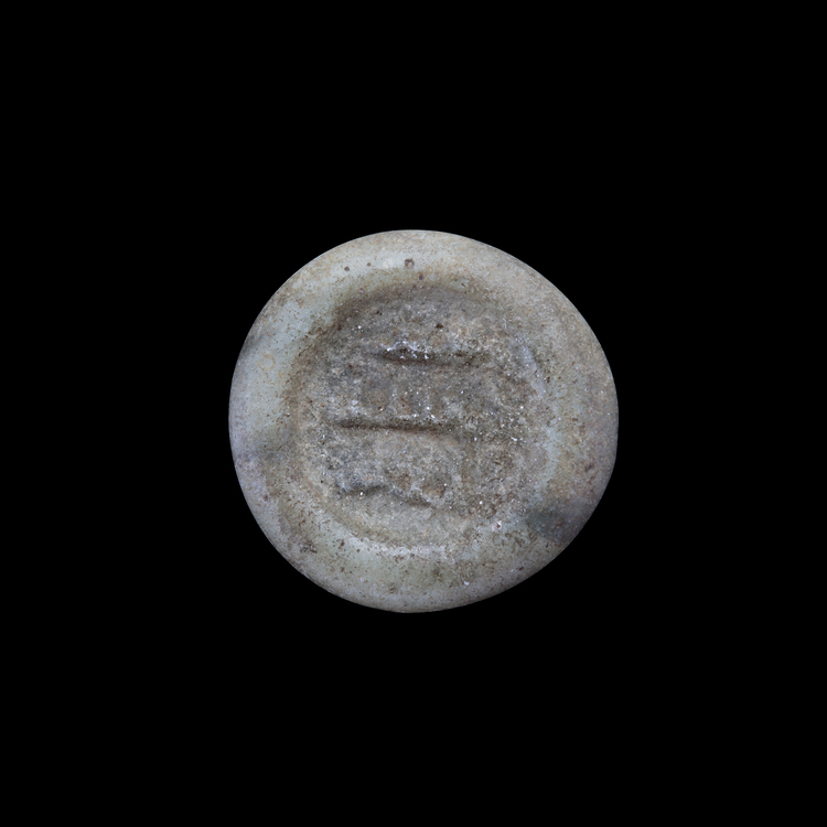 AN EARLY ISLAMIC GLASS WEIGHT OF HALF DIRHAM, 10TH-11TH CENTURY
