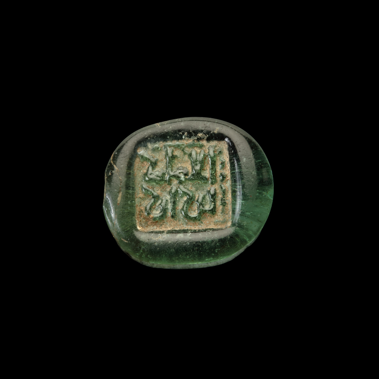AN EARLY ISLAMIC GLASS WEIGHT OF HALF DIRHAM