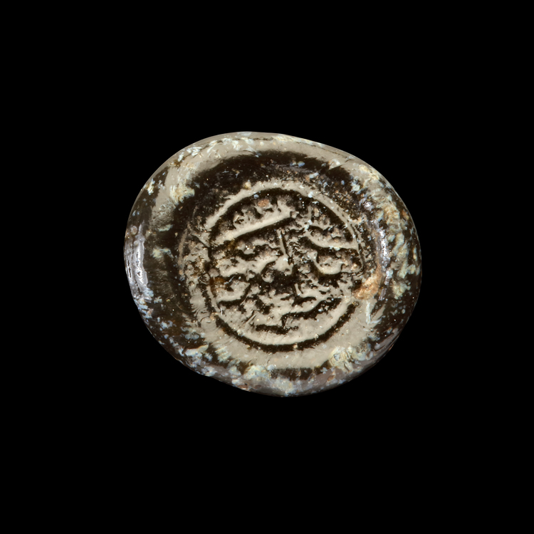 AN EARLY ISLAMIC GLASS WEIGHT OF QUARTER DIRHAM, 10TH-11TH CENTURY