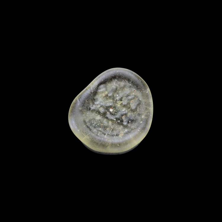 AN EARLY ISLAMIC GLASS WEIGHT OF QUARTER DIRHAM, 10TH-11TH CENTURY