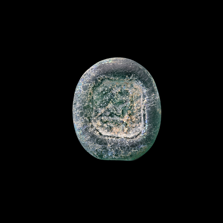 AN EARLY ISLAMIC GLASS WEIGHT OF HALF DIRHAM, 10TH-11TH CENTURY