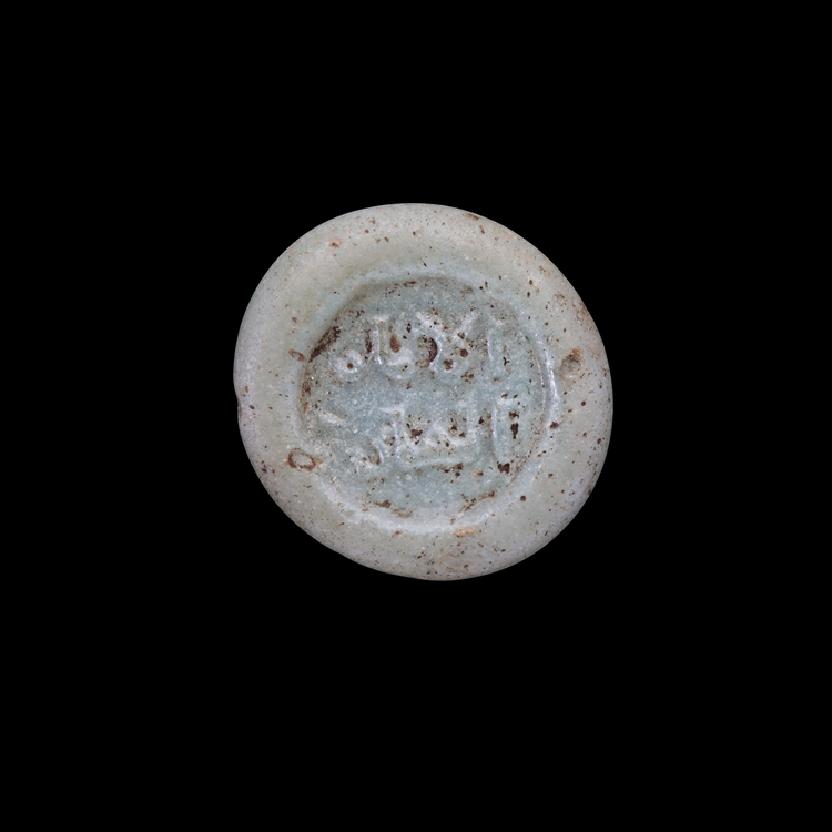 AN EARLY ISLAMIC GLASS WEIGHT OF HALF DIRHAM
