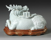 A CHINESE WHITE GLAZED SEATED DRAGON, QING DYNASTY (1644–1911)