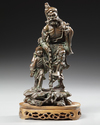 A CHINESE BRONZE FIGURE  OF LOHAN WITH A BOY, 19TH CENTURY