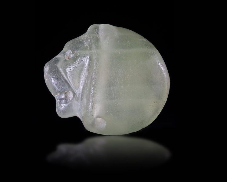 A NEAR EASTERN SEAL IN GREEN CALCITE IN THE FORM OF A LION'S HEAD, 3RD MILLENNIUM BC