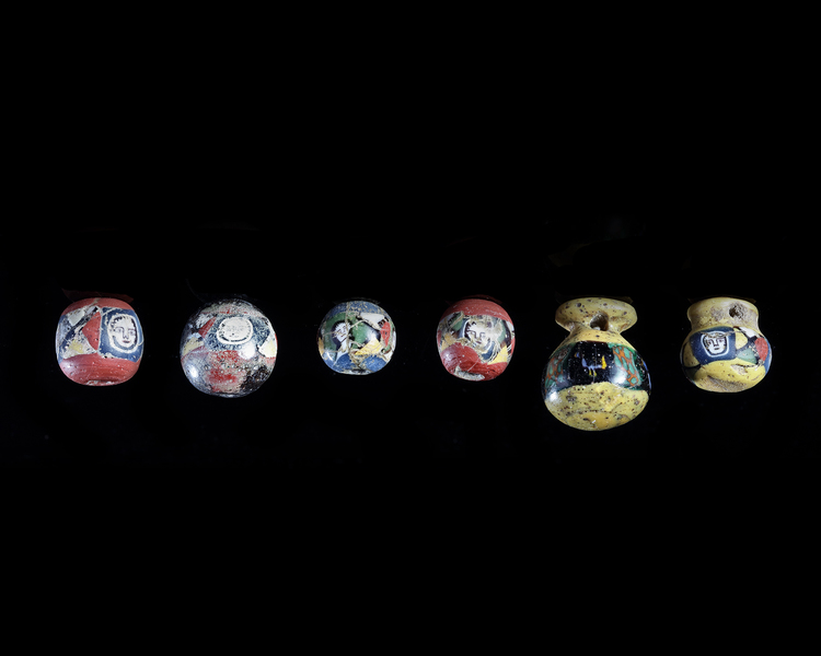 A GROUP OF SIX GLASS FACE BEADS AND PENDANTS, ROMAN, 1ST CENTURY AD