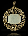 A GOLD MOUNTED TALISMANIC CARVED JADE PENDANT