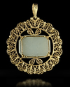 A GOLD MOUNTED TALISMANIC CARVED JADE PENDANT