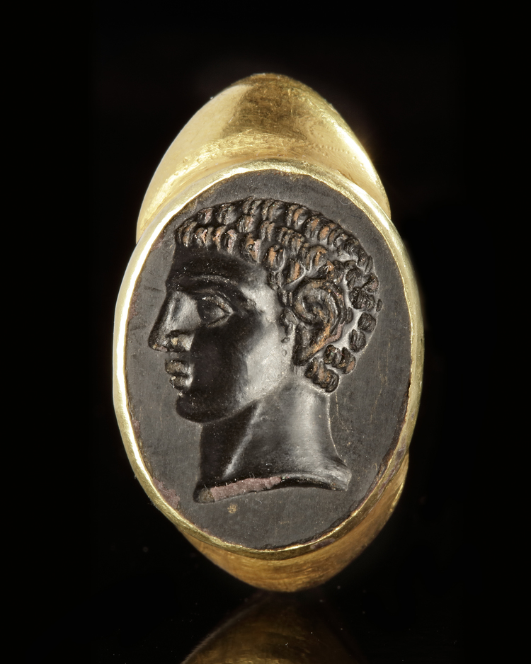 A LARGE ROMAN STYLE GOLD RING WITH AN INTAGLIO OF A YOUNG MAN FACING LEFT, 19TH CENTURY AD
