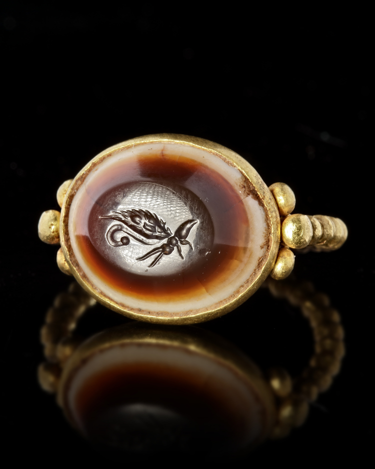 A LARGE ROMAN GOLD RING WITH AN INTAGLIO SHOWING A BUTTERFLY, 1ST CENTURY AD