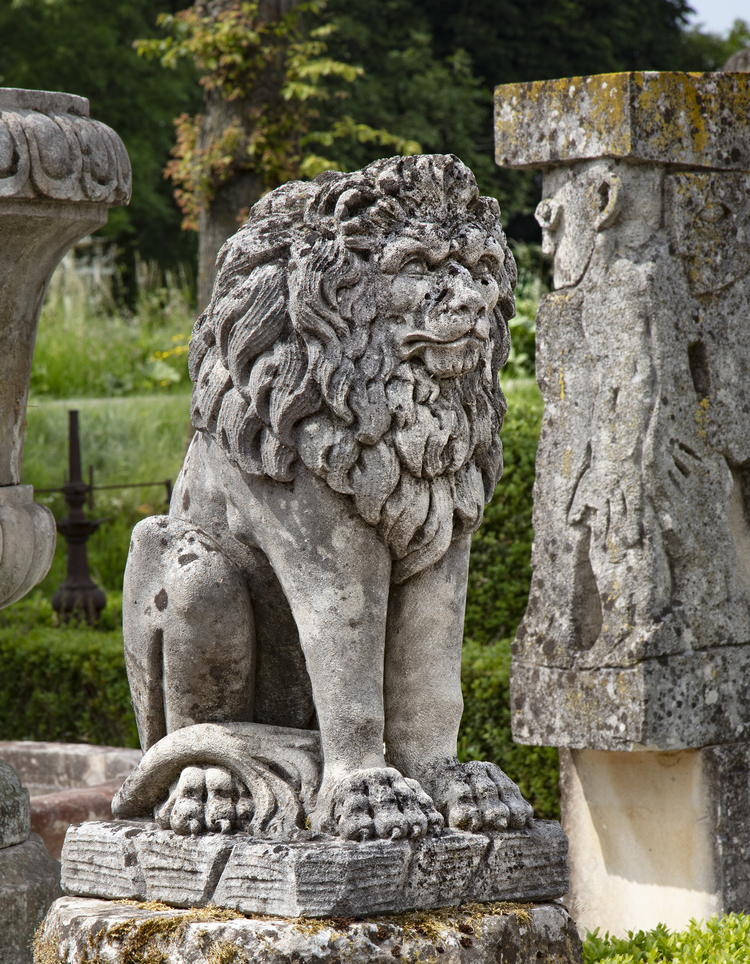 A SCULPTED LIMESTONE MODEL OF A SEATED LION, FIRST QUARTER 20TH CENTURY