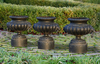 A SET OF THREE FRENCH BLACK PAINTED CAST IRON VASES, LATE 19TH CENTURY, BY FONDERIE CORNEAU ALFRED, CHARLEVILLE