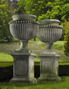 A PAIR OF LARGE AND IMPRESSIVE CARVED LIMESTONE GARDEN URNS ON PLINTHS IN IMPERIO TASTE, LATE 20TH CENTURY