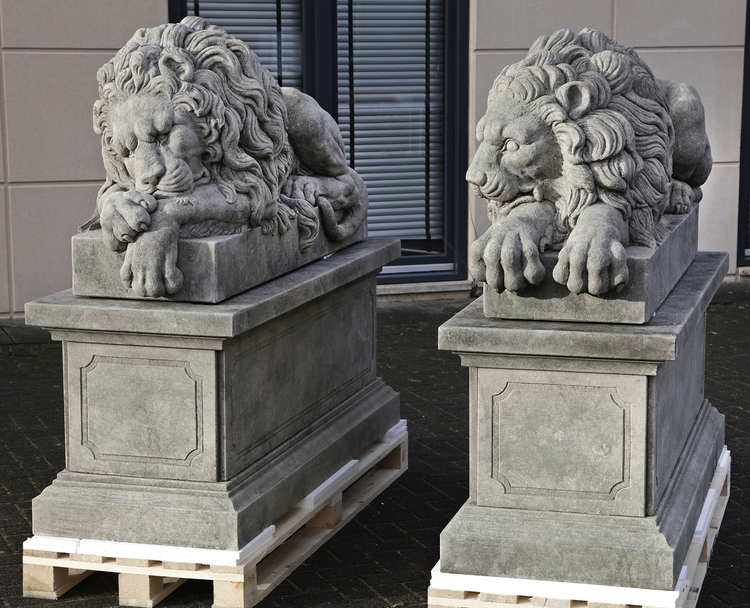 A PAIR OF SCULPTED LIMESTONE MODELS OF RECUMBENT LIONS, SECOND HALF ...