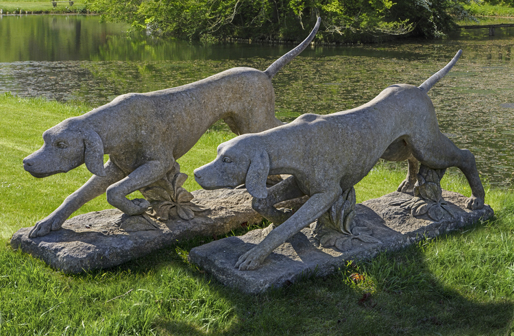 A PAIR OF CARVED LIMESTONE MODELS OF HOUNDS, PROBABLY ENGLISH POINTERS, 20TH CENTURY