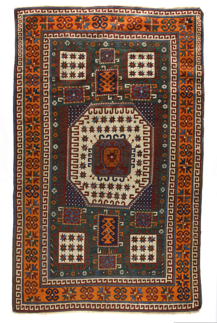 A KARACHOF KAZAK RUG WITH GREEN BACKGROUND