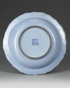 A CHINESE BLUE-GROUND SLIP DECORATED DISH, QIANLONG SIX-CHARACTER SEAL MARK IN UNDERGLAZE BLUE AND OF THE PERIOD (1736-1795)