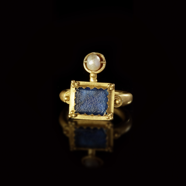 A GOLD RING WITH A BLUE GLASS INLAY, 1ST CENTURY AD OR LATER