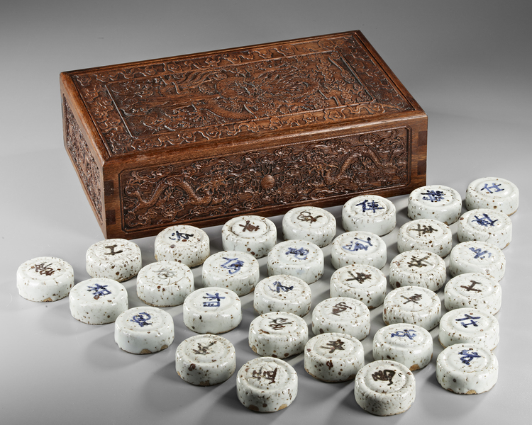 A COLLECTION OF CHINESE WHITE-GLAZED SCROLL WEIGHTS IN A CARVED WOODEN BOX