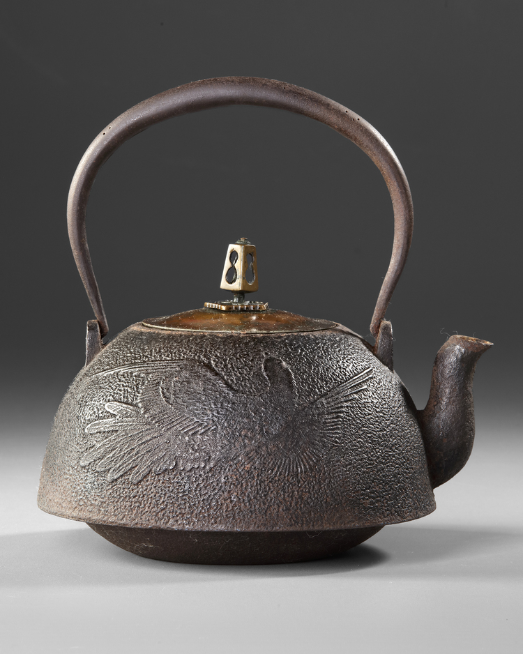 A JAPANESE CAST IRON TETSUBIN – CRANE AND WAVES DESIGN WITH BRONZE LID,EDO PERIOD (1615–1868)