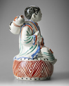 A JAPANESE FIGURE OF A BOY ON DRUM,1670-1690
