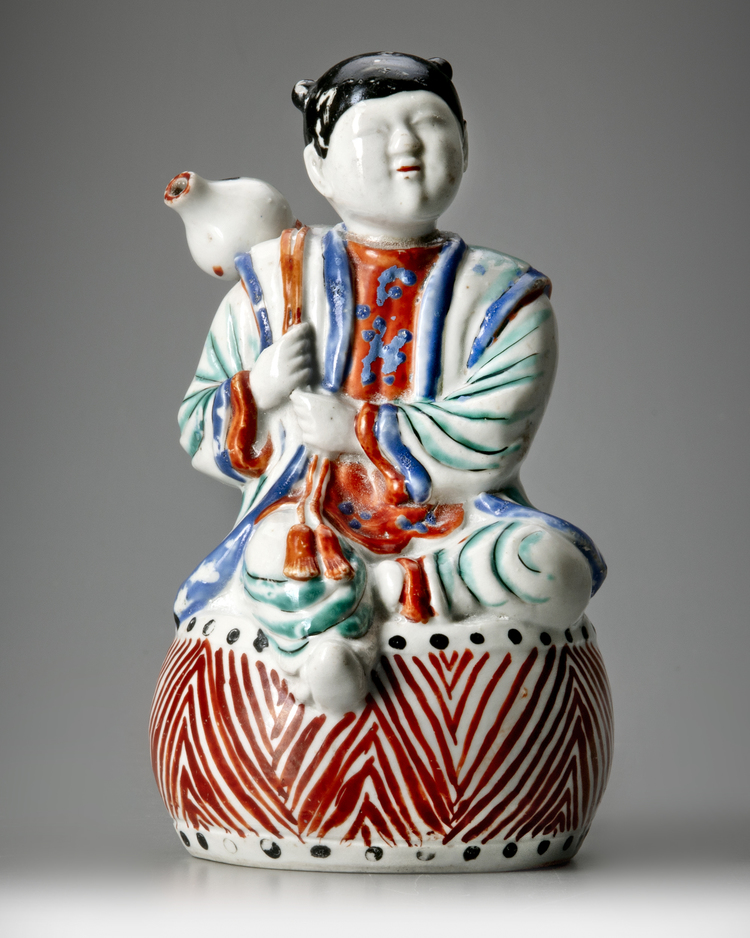 A JAPANESE FIGURE OF A BOY ON DRUM,1670-1690