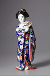 A JAPANESE KUTANI PORCELAIN FIGURE OF A GEISHA, SHOWA PERIOD, 1930's