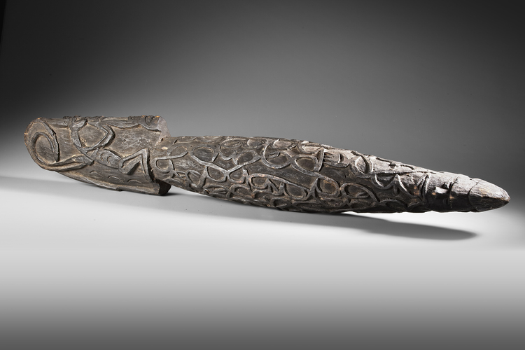Large Asmat neckroll with ancestor heads, praying mantis and other headhunting motifs.