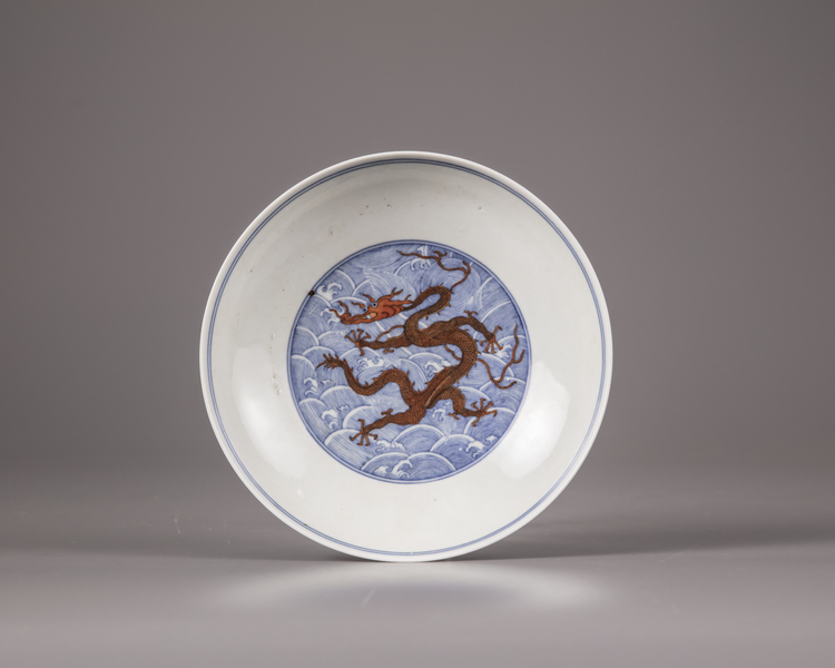 A Chinese iron-red-decorated blue and white 'dragon' dish