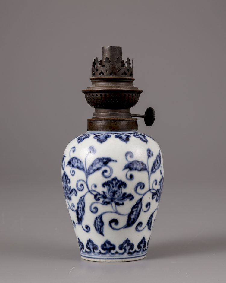 A Chinese blue and white jar with a copper oil lamp cover