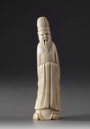 A Chinese ivory carving of a standing scholar