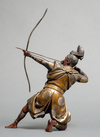 A bronze figure of a Samurai warrior resting on one knee while tensioning a bow